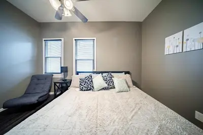 a bedroom with a bed and a blue chair at Little Italy Gem Close to CWRU, Cleveland Clinic & Top Restaurants w King Bed in Cleveland