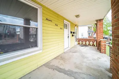 a yellow house with a door and a window at Little Italy Gem Close to CWRU, Cleveland Clinic & Top Restaurants w King Bed in Cleveland