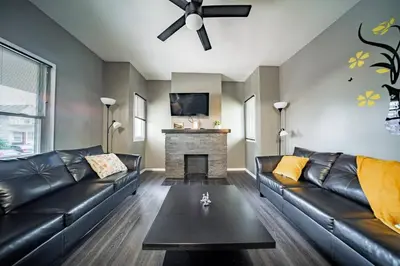 a living room with a leather couch and a fireplace at Little Italy Gem Close to CWRU, Cleveland Clinic & Top Restaurants w King Bed in Cleveland