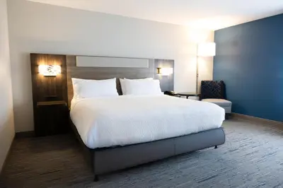 a bedroom with a large bed with white sheets and pillows at Holiday Inn Express & Suites Mansfield - Ontario by IHG in Mansfield
