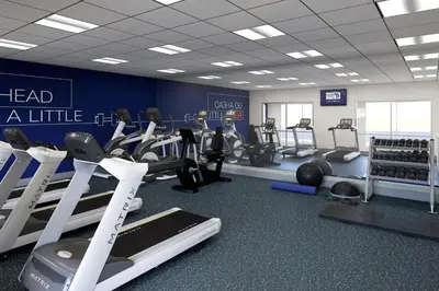 a gym with treadmills and machines in a room at Holiday Inn Express & Suites Mansfield - Ontario by IHG in Mansfield