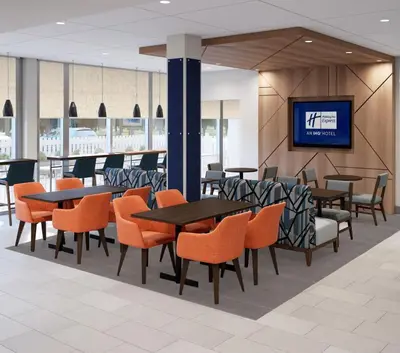 a restaurant with tables and chairs and a tv at Holiday Inn Express & Suites Mansfield - Ontario by IHG in Mansfield