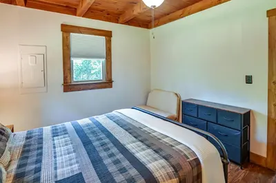 a bedroom with a bed and a dresser and a window at Creek, Trails and Falls! Rural Red River Gorge Cabin in Campton