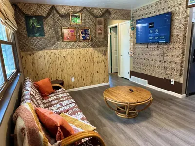 a living room with a couch and a table at Kikis Tikis! Fun Themed Home in Vermilion