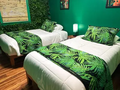 two beds in a room with green walls at Kikis Tikis! Fun Themed Home in Vermilion