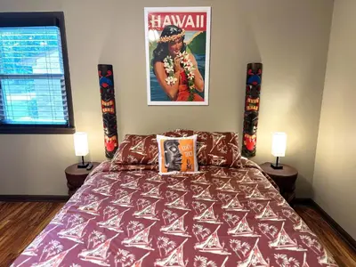 a bedroom with a bed with a poster on the wall at Kikis Tikis! Fun Themed Home in Vermilion