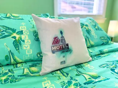 a bed with a pillow on top of it at Kikis Tikis! Fun Themed Home in Vermilion
