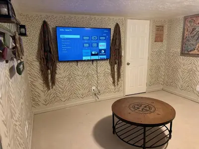 a room with a table and a tv on the wall at Kikis Tikis! Fun Themed Home in Vermilion