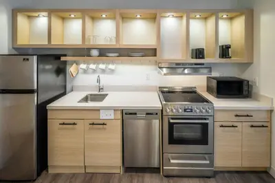 a kitchen with stainless steel appliances and wooden cabinets at TownePlace Suites by Marriott Canfield in Canfield