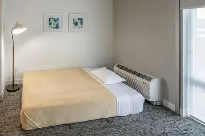 a bedroom with a bed and an air conditioner at TownePlace Suites by Marriott Canfield in Canfield