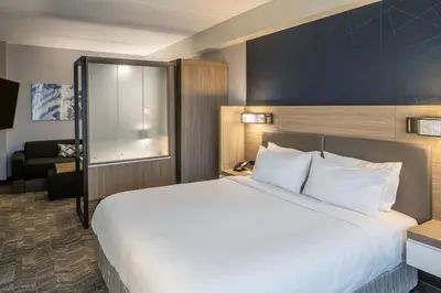 a hotel room with a large bed and a chair at SpringHill Suites by Marriott Canfield in Canfield