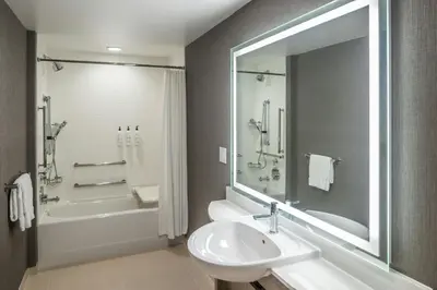 a bathroom with a sink and a tub and a shower at SpringHill Suites by Marriott Canfield in Canfield