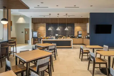 a restaurant with tables and chairs and a kitchen at SpringHill Suites by Marriott Canfield in Canfield