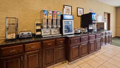a restaurant with a counter with a coffee shop at Best Western Penn-Ohio Inn & Suites in Hubbard