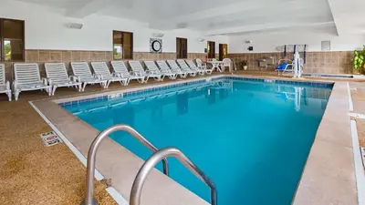 a large swimming pool with chairs in a building at Best Western Penn-Ohio Inn & Suites in Hubbard
