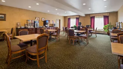 a restaurant with tables and chairs in a room at Best Western Penn-Ohio Inn & Suites in Hubbard