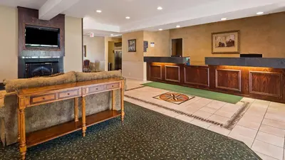 a large lobby with a large couch and a television at Best Western Penn-Ohio Inn & Suites in Hubbard