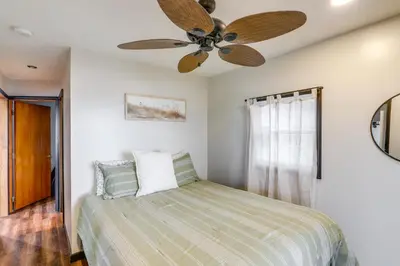a bedroom with a bed with a ceiling fan at Vickery Cottage on Sandusky Bay with Fire Pit! in Port Clinton