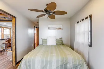 a bedroom with a bed with a ceiling fan at Vickery Cottage on Sandusky Bay with Fire Pit! in Port Clinton