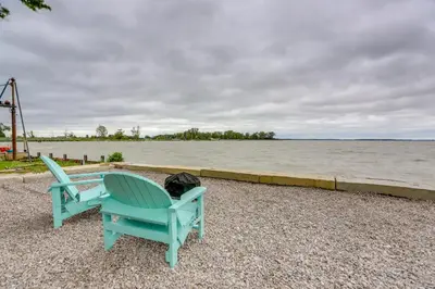 two chairs sitting next to a body of water at Vickery Cottage on Sandusky Bay with Fire Pit! in Port Clinton