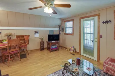 a living room with a table and a ceiling fan at Dog-Friendly Home Rental about 5 Mi to Cave Run Lake! in Wellington