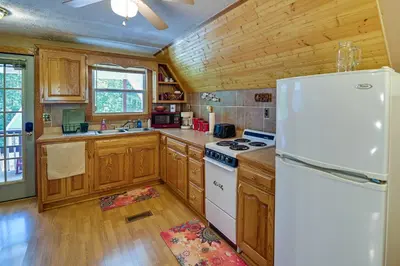 a kitchen with wooden cabinets and a white refrigerator at Dog-Friendly Home Rental about 5 Mi to Cave Run Lake! in Wellington
