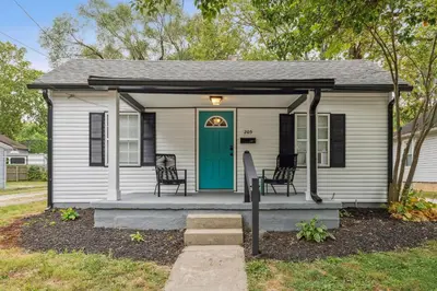 a small white house with a green door at Elm Two Bedroom House in Historic Loveland in Loveland