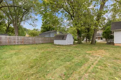 a yard with a fence and a white shed at Elm Two Bedroom House in Historic Loveland in Loveland