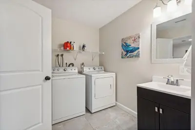 a bathroom with a washer and dryer and a sink at Elm Two Bedroom House in Historic Loveland in Loveland