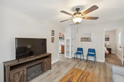 a living room with a flat screen tv and two blue chairs at Elm Two Bedroom House in Historic Loveland in Loveland