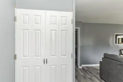a white closet door in a living room with a couch at Cozy Retreat in Cincinnati home in Cincinnati