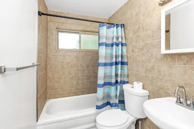 a bathroom with a toilet and a tub and a sink at Cozy Retreat in Cincinnati home in Cincinnati