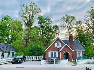 a red brick house with a white fence at Cottage for 12, Close to Ark, Private Parking, 4BR in Williamstown