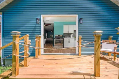 a blue house with a wooden deck with a kitchen at Buckeye Lake Cottage