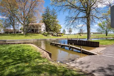 a small river with a house in the background at Buckeye Lake Cottage
