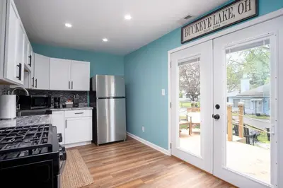 a kitchen with blue walls and a refrigerator at Buckeye Lake Cottage