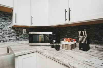 a kitchen with white cabinets and a counter top at Buckeye Lake Cottage