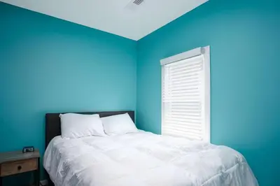 a blue bedroom with a bed and a window at Buckeye Lake Cottage