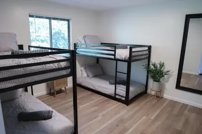 two bunk beds in a room with a mirror at 5-BR Serene Retreat Near CLE* Dogs welcome! in Berea