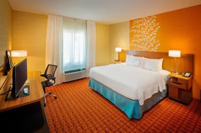 a hotel room with a bed and a flat screen tv at Fairfield Inn and Suites by Marriott Monaca in Monaca