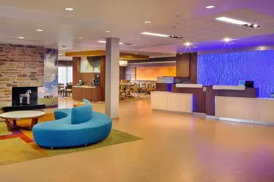 a lobby with a blue chair and a table at Fairfield Inn and Suites by Marriott Monaca in Monaca