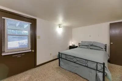 a bedroom with a bed and a window at Riverfront Covington Cabin with Deck and Fire Pit! in Piqua