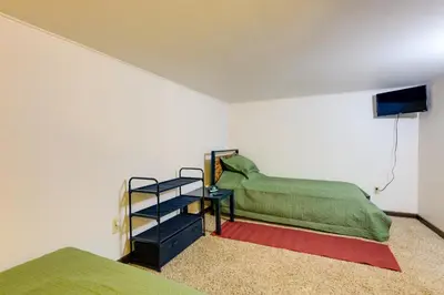 a bedroom with a bed and a table with a shelf at Riverfront Covington Cabin with Deck and Fire Pit! in Piqua