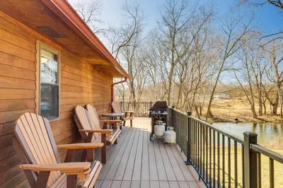 a porch with chairs and a grill on a house at Riverfront Covington Cabin with Deck and Fire Pit! in Piqua