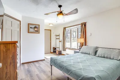 a bedroom with a bed and a ceiling fan at Riverfront Covington Cabin with Deck and Fire Pit! in Piqua