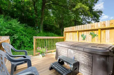 a wooden deck with a hot tub and a grill at Frog Hollow at Hocking Vacations in Logan