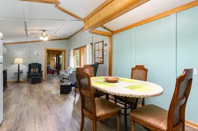 a dining room and living room with a table and chairs at Frog Hollow at Hocking Vacations in Logan