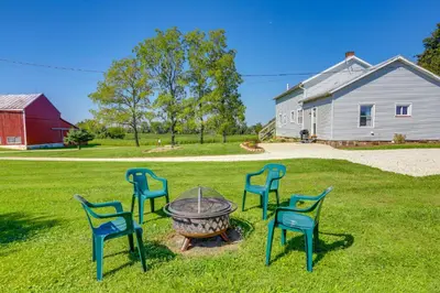 a group of chairs around a fire pit in a yard at Cozy Greenwich Vacation Rental with Fire Pit in Greenwich