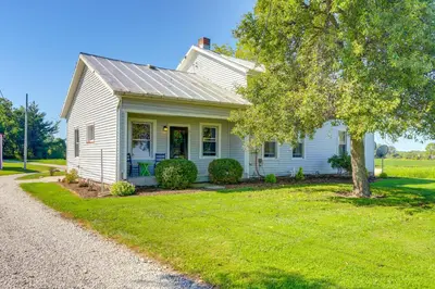 a white house with a tree in the yard at Cozy Greenwich Vacation Rental with Fire Pit in Greenwich