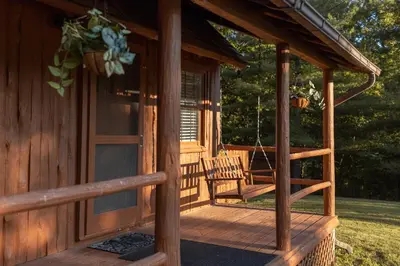 a porch of a log cabin with a swing at Athens and Albany's Hillside Haven in Albany